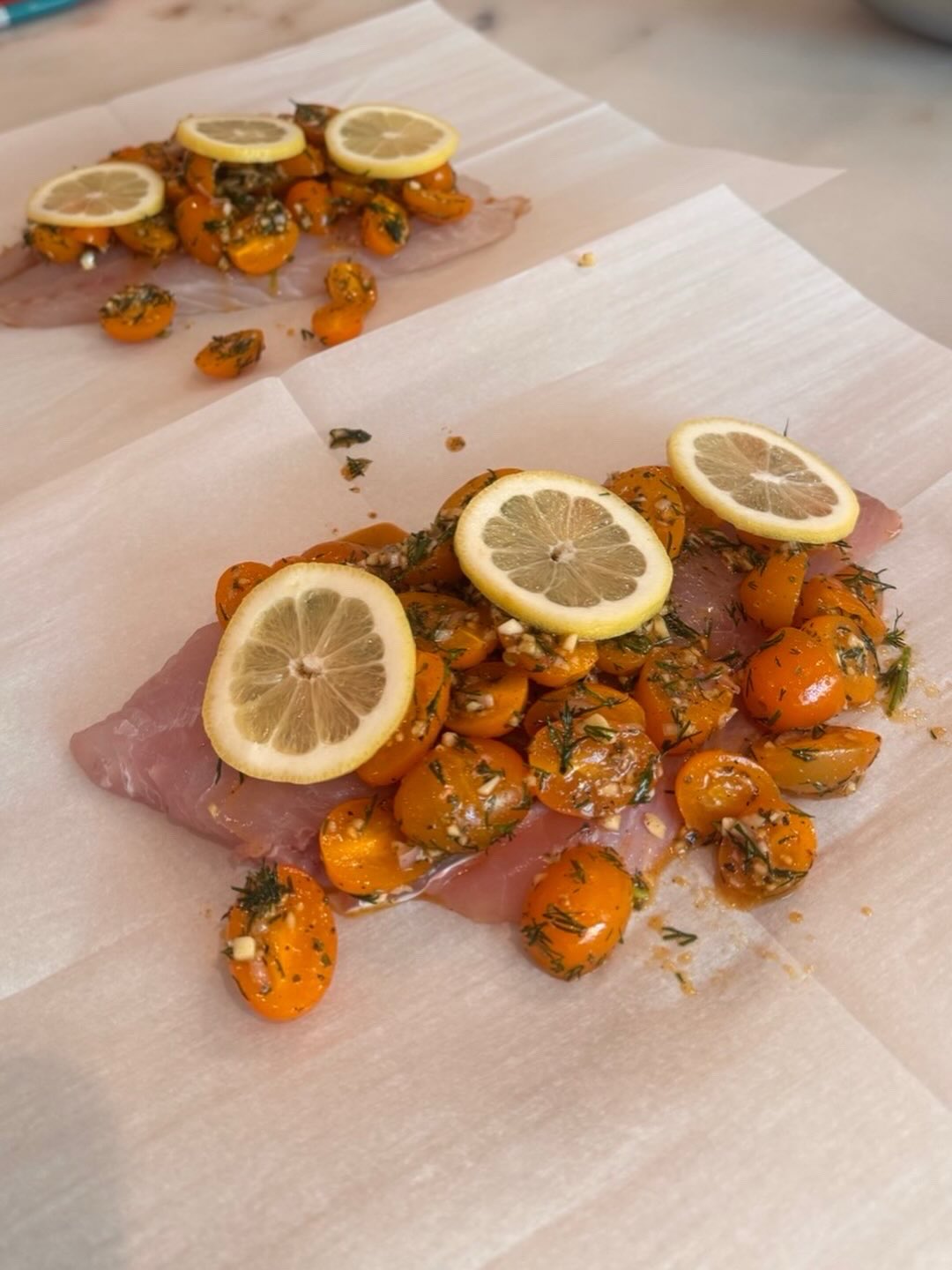 Fish with lemon and cherry tomatoes on parchment